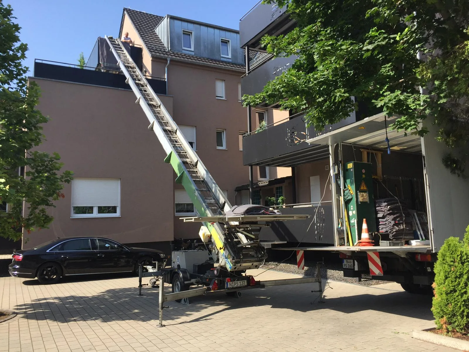 Umzugswagen mit Hebebühne vor einem Wohngebäude