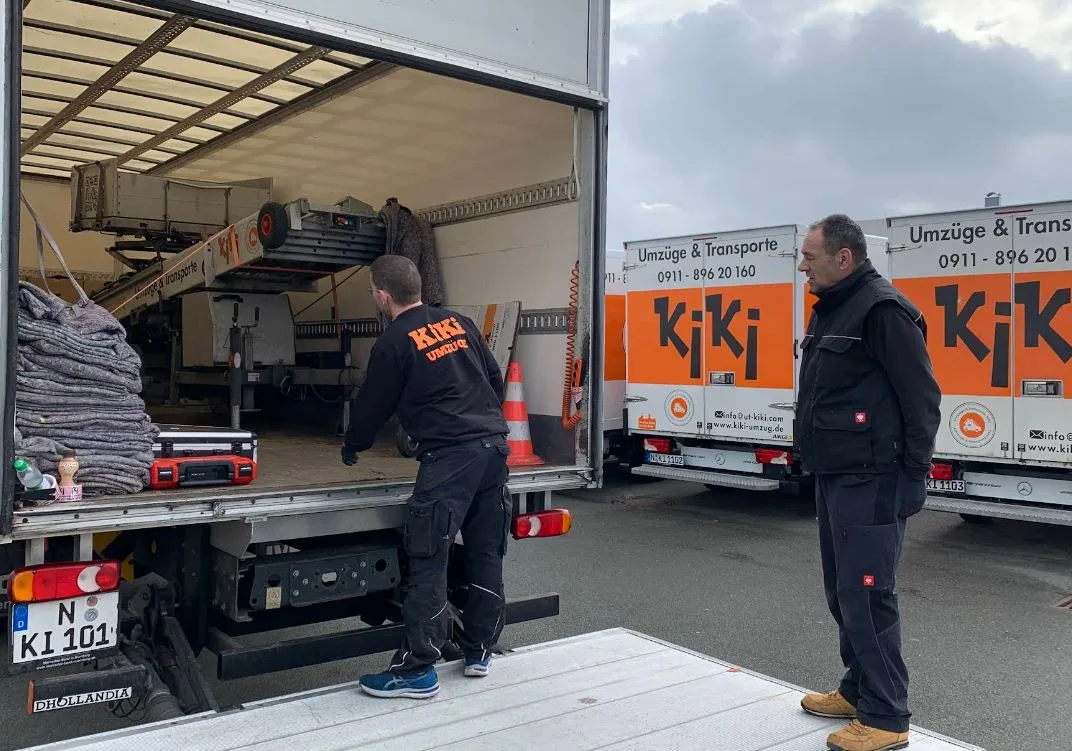 Mitarbeiter laden Möbel in einen Transporter